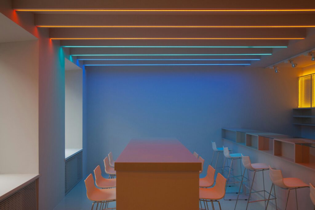 A minimalist room featuring colorful neon lighting and modern furniture design.